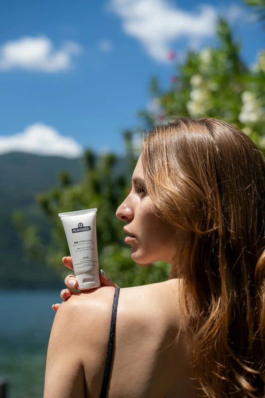 Woman is holding sunscreen in sunlight