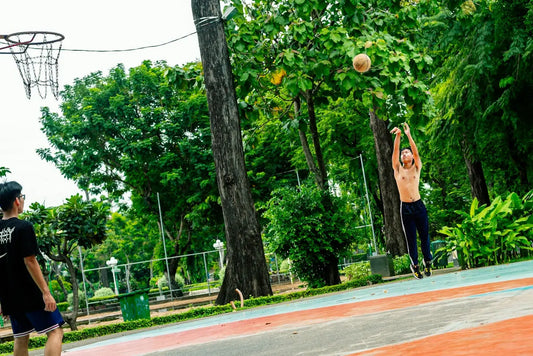 Two men playing basketball on an outdoor court