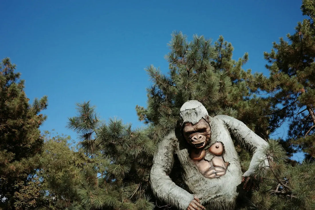 A large ape-like figure stands among trees